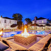 Luxury poolside seating scene illuminated by the powerful glow of a square brick fire pit powered by an HPC Fire square flat burner / creating the ultimate outdoor retreat with ambiance and warmth.