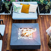 Charming rooftop or patio deck showcasing a dark textured concrete fire pit with an HPC flat burner / bright flame rising through white stone media, creating a cozy vibe in a compact, stylish outdoor space.