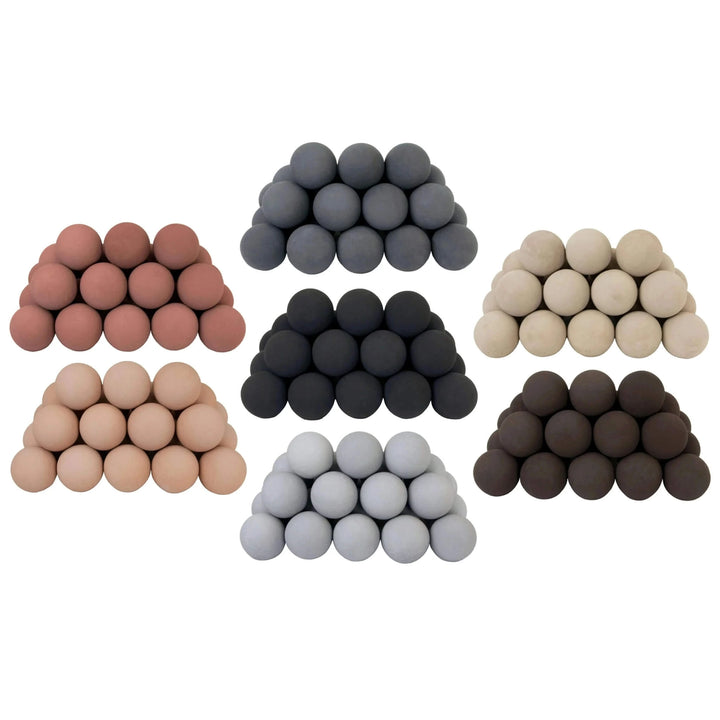 Collage of Rasmussen FireBalls in seven stylish color options / black, dark gray, light gray, beige, natural, adobe red, and brown / each arranged in a pyramid stack to showcase their modern, geometric design. These ceramic fireballs offer a sleek and contemporary alternative to traditional gas logs, perfect for customizing your fireplace with a minimalist or bold look.