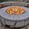 Beautifully built-in stone fire pit featuring the Starfire Designs 36-inch fire pit ring burner with vibrant, full flames dancing over lava rock. Surrounded by a stylish light-colored stone coping and integrated venting panel for proper airflow, this outdoor gas fire pit is the perfect backyard centerpiece for cozy evenings and gatherings.