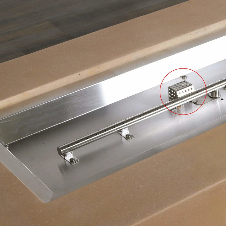 Installed Starfire Designs Béton Fire Pit Ignition Shield protecting the ignition system within a stainless steel burner tray, highlighted in red for clarity.