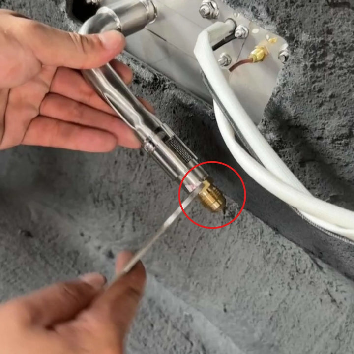 Technician installing the Starfire Designs Béton Fire Pit Replacement Orifice on a stainless steel gas line, demonstrating how the brass fitting connects to the burner assembly.