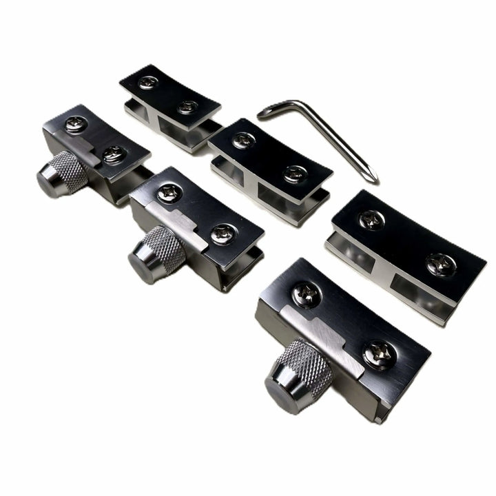 Close-up of the Starfire Designs Béton Fire Pit Replacement Round Glass Wind Guard Clips Kit showing four stainless steel clips with adjustment knobs and an included hex key tool.