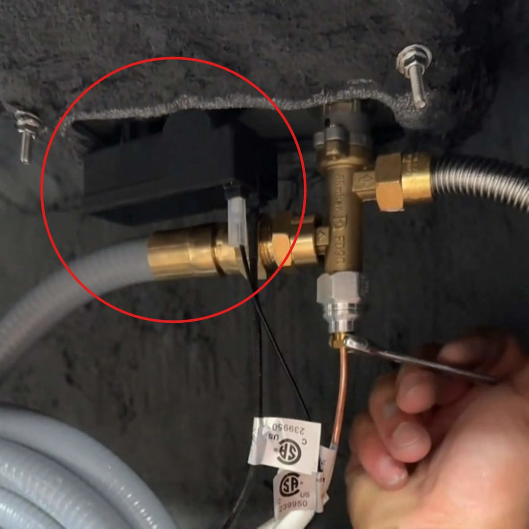 Starfire Designs Béton Fire Pit Spark Button shown installed beneath the burner assembly, connected to brass fittings and ignition wiring for functional use.