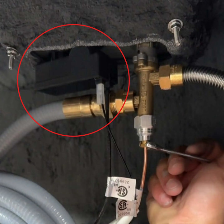 Starfire Designs Béton Fire Pit Spark Button shown installed beneath the burner assembly, connected to brass fittings and ignition wiring for functional use.