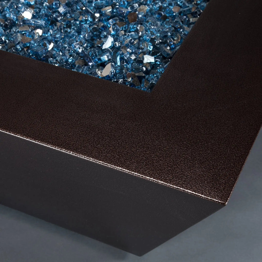 Close-up of Steel Mill 48-inch by 32-inch Rectangle Gas Fire Pit - copper vein, focusing on the textured finish and shimmering blue fire glass