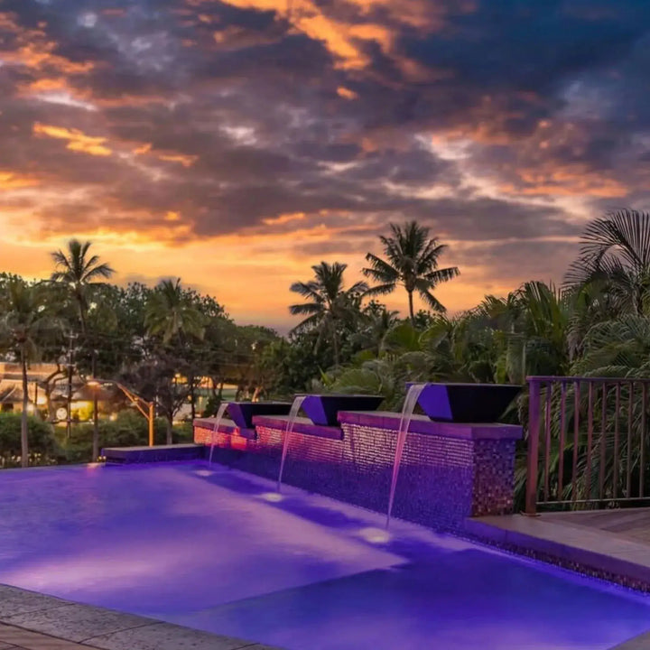 Dark Maya GFRC concrete water bowls with copper scuppers pouring smooth streams into a glowing infinity pool at sunset, adding luxury and resort-style ambiance.