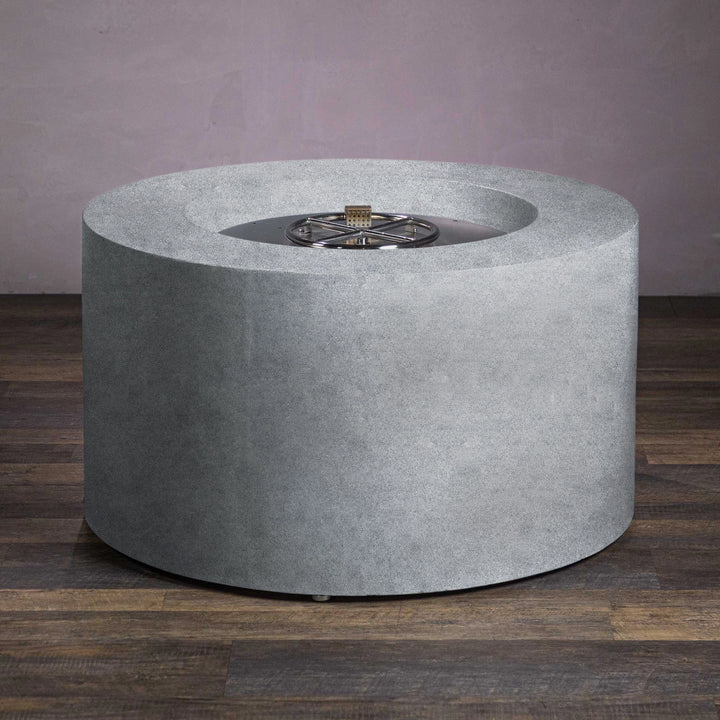 Close-up of the unlit burner in the Beton 42-inch natural gray round concrete gas fire pit. The fire pit features a stainless steel circular burner set in a modern concrete body. The lava rocks and high-quality materials ensure durability and functionality, making this outdoor gas fire pit a perfect addition to any backyard or patio fire pit setup