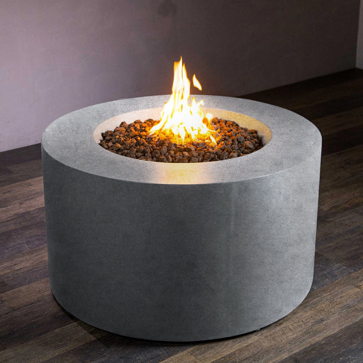 Front view of the Beton 42-inch natural gray round concrete gas fire pit with access door. The fire pit showcases a natural gray concrete body with a circular fire area, and its modern design features durable lava rocks surrounding the burner. The built-in access door allows easy access to the propane tank, making it a practical choice for any outdoor space. Ideal for a backyard fire pit, natural gas fire pit, and luxury outdoor fire pit.