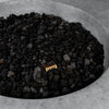 A close-up of the lava rocks inside the Beton 42-inch natural gray round concrete fire pit. The durable materials and seamless design enhance the pit’s long-lasting functionality, while the natural gas burner provides consistent, high-efficiency flames.