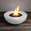 This image showcases the Beton 42" White Round Concrete Natural Gas Fire Pit with a clean modern design. The circular shape features a bright white concrete finish and is complemented by a centered, brilliant flame burning with the help of black lava rocks. This fire pit is equipped with a push-button ignition for easy operation. Ideal for outdoor living spaces, this natural gas fire pit adds warmth and ambiance to any setting. 