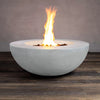 The Beton 42" White Round Concrete Fire Pit is displayed with the flame fully lit, offering a front view. The smooth concrete finish in white pairs elegantly with the intense flames rising from the central burner, surrounded by lava rocks. This natural gas fire pit includes a push-button ignition system for ease of use. It’s perfect for modern outdoor decor, providing both function and beauty to patios or backyard areas.