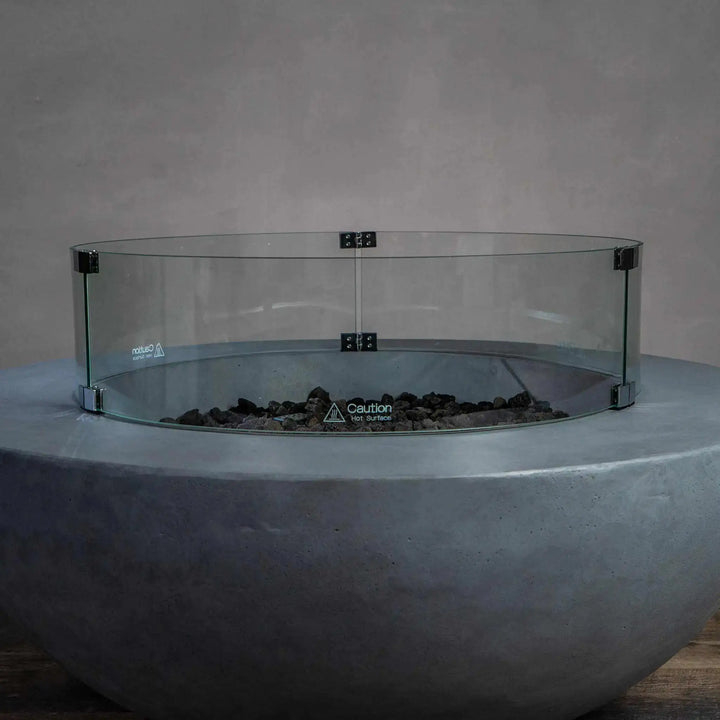 Starfire Designs Beton Round Glass Wind Guard mounted on a concrete fire pit, showcasing a sleek and protective design without the flame