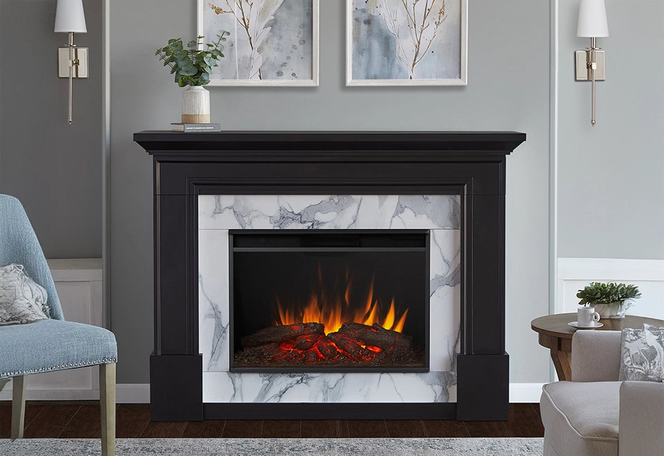 Elegant black mantel electric fireplace with a white marble surround, featuring realistic flames and glowing embers in a cozy living room setting.