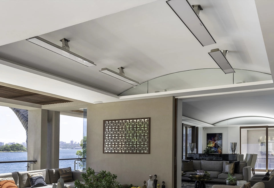 Modern patio with sleek ceiling-mounted heater control systems, providing efficient temperature regulation for indoor-outdoor living spaces with waterfront views.