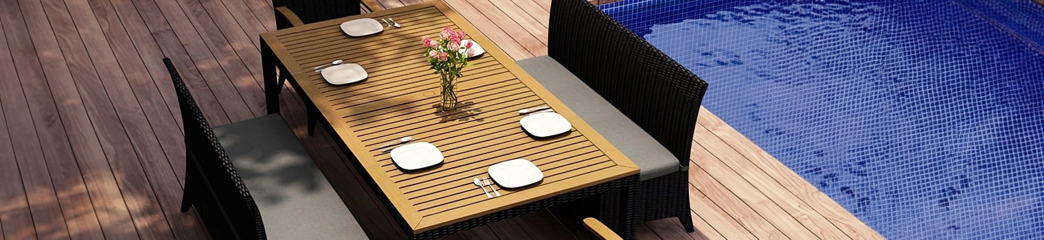 Elegant outdoor dining set with a wooden table and wicker chairs arranged on a deck beside a pool, featuring a centerpiece of flowers and place settings, ideal for al fresco dining and outdoor gatherings