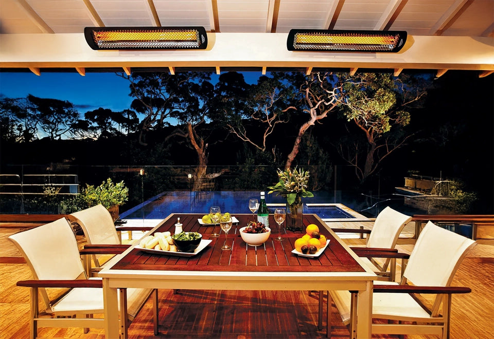 Ceiling-mounted commercial outdoor heaters providing warmth to a cozy dining area by the pool during the evening.