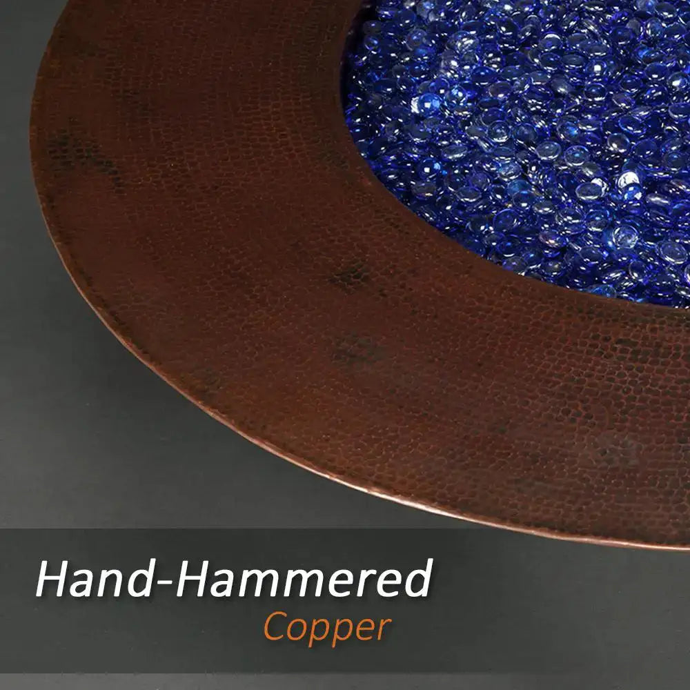 Close-up of the hand-hammered copper rim of the Cono Moreno 42-inch Round Copper Fire Pit, showcasing the detailed craftsmanship with blue fire glass