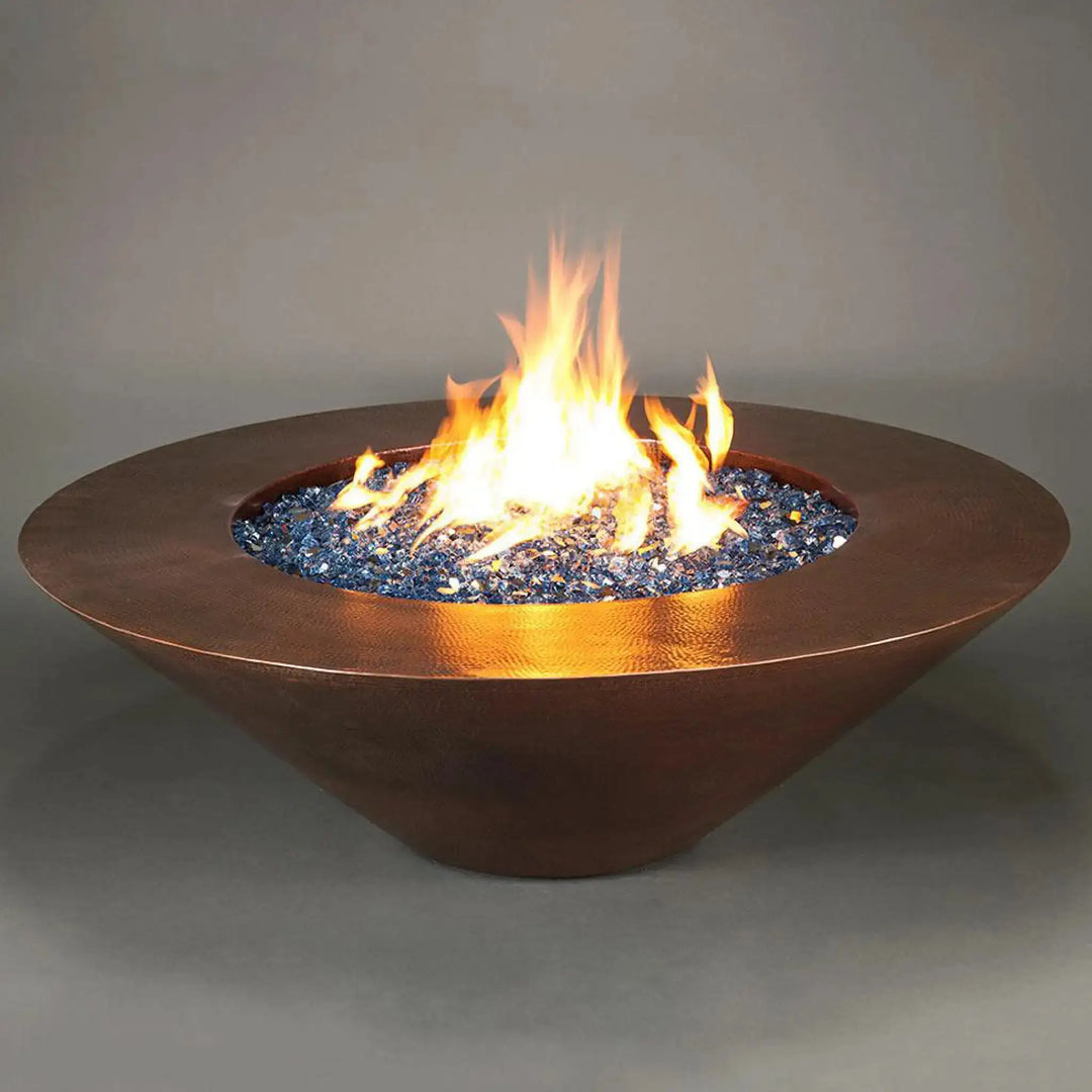 Cono Moreno 60-inch Round Copper Fire Pit with vibrant blue fire glass and dynamic flames, showcasing the elegant hand-hammered copper finish