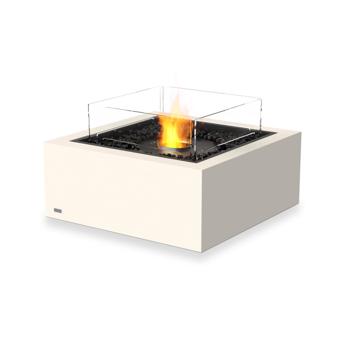 A modern EcoSmart Fire Base 30 Bone ethanol fire pit featuring a black burner with a protective wind guard. The sleek, square concrete fire pit is filled with black fire media and a strong glass wind guard, ensuring safety and a stable flame. Designed for luxury outdoor heating, this ethanol fire table adds warmth and ambiance to any patio or backyard space.