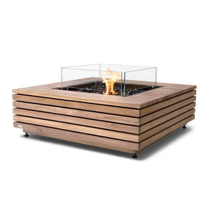 The EcoSmart Fire Base 40 Teak Fire Pit Table features a black ethanol burner surrounded by a tempered glass wind guard, adding both safety and elegance. This outdoor fire pit is constructed from sustainable teak wood slats, offering a natural finish that complements modern patios. The square gas fire pit provides eco-friendly ethanol flames, making it an ideal luxury fire feature for any backyard or commercial space.