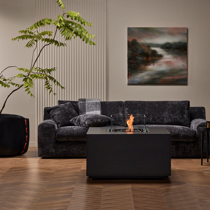 The EcoSmart Fire Chaser 38 Natural is featured in a moody, sophisticated living room with rich dark tones. This high-end fire feature adds ambiance and elegance to modern interior spaces.