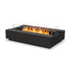 A modern EcoSmart Fire Cosmo 50 Graphite rectangular gas fire pit with a black burner and glass wind guard, providing an elegant outdoor heating solution. The graphite concrete base enhances durability, while the natural gas fire pit delivers a clean-burning flame over black fire media. Perfect for patios and backyard fire pit setups.