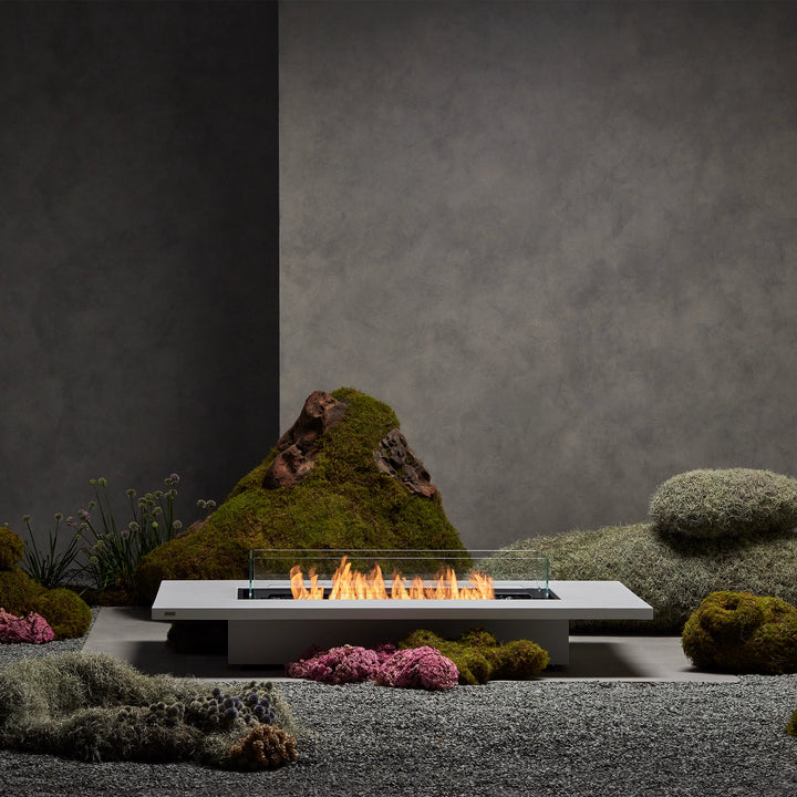 The EcoSmart Fire Daiquiri 70 in an elegant garden setting with moss and stone elements. A natural gas fire pit perfect for modern outdoor fire pits.