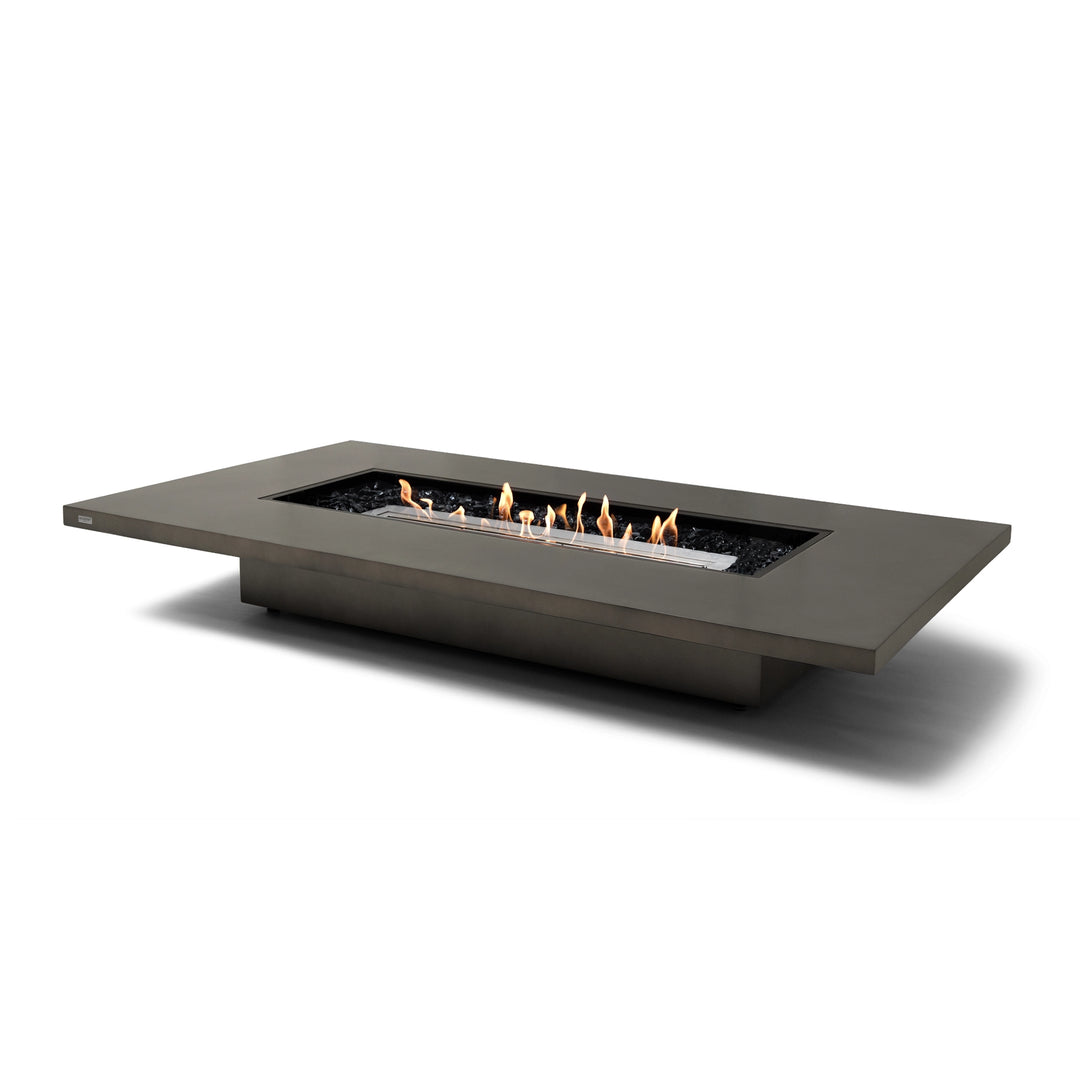 The EcoSmart Fire Daiquiri 70 Natural Gas Fire Pit Table showcases a stainless steel burner within its modern natural gray concrete structure. This outdoor fire table is perfect for creating a cozy atmosphere, offering a luxurious, contemporary design for patios, gardens, and outdoor lounges. Its weather-resistant build and elegant elongated flame make it an ideal choice for both residential and commercial spaces.