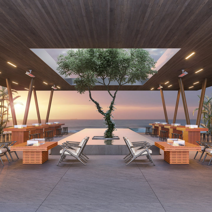 A stunning outdoor dining area featuring multiple EcoSmart Fire Gin 90 (Bar) Teak Fire Pits, set against a scenic sunset. These modern fire pits provide warmth and ambiance for restaurants, hotels, and commercial outdoor spaces. With their sleek teak wood finish and integrated gas fire pit design, they enhance the outdoor atmosphere for an unforgettable dining experience.