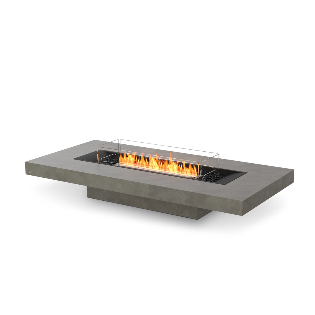 The EcoSmart Fire Gin 90 (Low) Natural gas fire pit table features a black burner with a glass wind guard. This modern outdoor fire table has a sleek low-profile design, perfect for patios, backyards, and luxury fire pit settings. The natural finish complements contemporary outdoor spaces, and the wind guard enhances flame stability in various weather conditions.