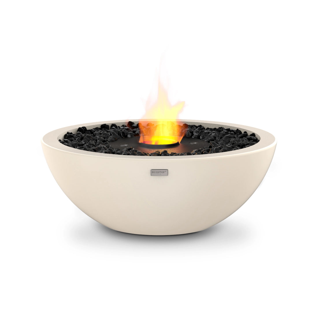 The EcoSmart Fire Mix 600 Bone Fire Pit features a sleek bone-colored concrete bowl with a black burner at the center, surrounded by black fire-resistant stones. This modern outdoor fire pit is designed for bioethanol fuel, offering a clean-burning, smoke-free flame that enhances any patio or backyard setting.