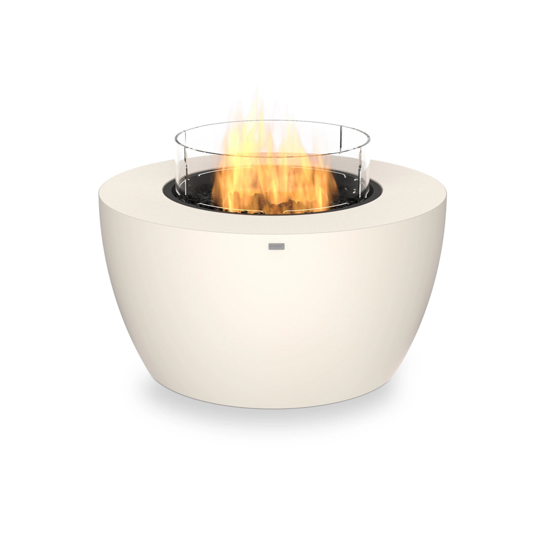 A bone-colored EcoSmart Fire Pod 40 propane fire pit with a glass wind guard, delivering an elegant flame display. This round propane fire pit is a freestanding fire bowl, perfect for enhancing any outdoor lounge or patio setup.