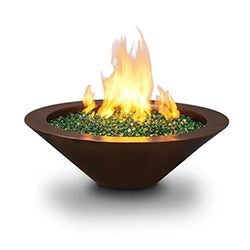 Round, bowl-shaped fire pit with a rustic brown finish, filled with green fire glass and bright flames rising from the center