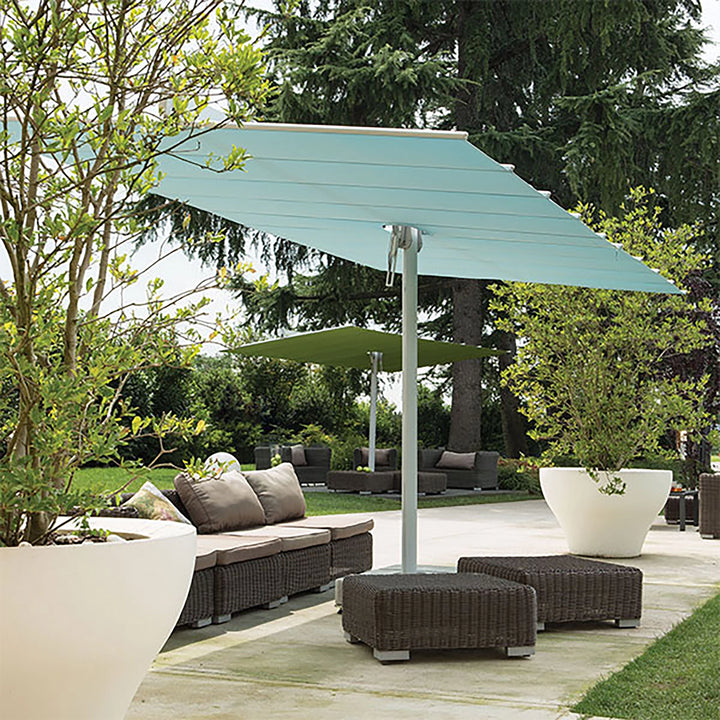 Full view of the FIM Umbrellas Flexy Twin 8x17' Rectangular Dual Shade Umbrella set up in a backyard setting. The dual shade canopies provide extensive coverage for multiple seating areas, making it perfect for entertaining guests in a stylish outdoor lounge space. The modern design and functionality suit both residential and commercial applications.