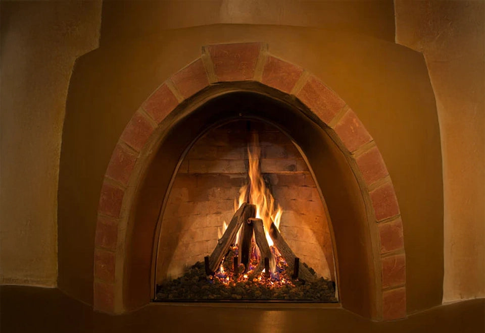 Cozy kiva-style natural gas fireplace with realistic log set and ember media, creating a warm and inviting ambiance.