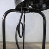 Close-up view of the gas hose connection and base support legs of the Golden Flame Outdoor Natural Gas Patio Heater. The image showcases the durable black steel frame with curved support brackets securely attached with bolts, ensuring stability and safety. The coiled natural gas hose is visibly looped, demonstrating a clean and organized setup for efficient gas flow. Ideal for highlighting the robust construction and engineering quality of the patio heater.