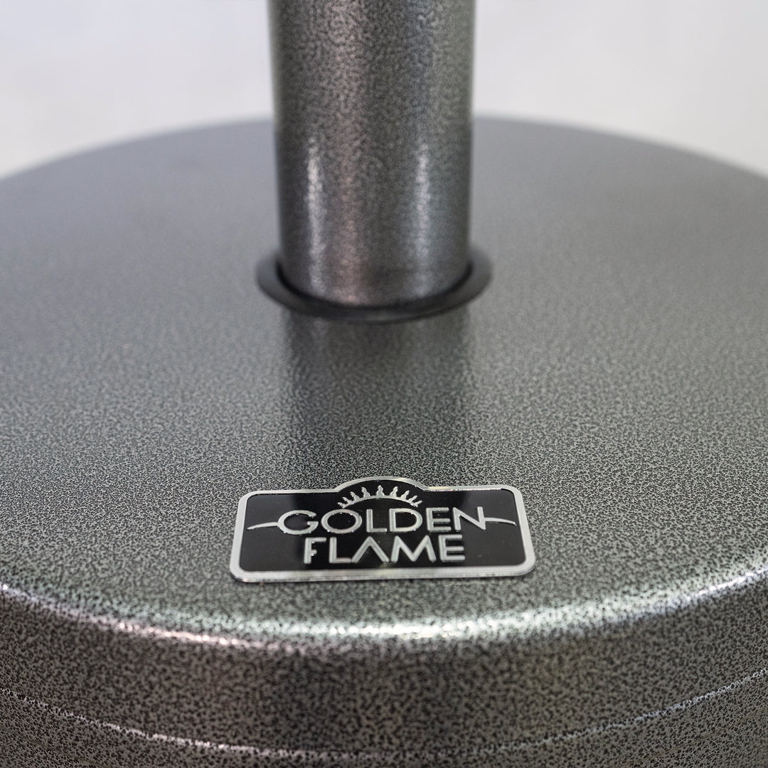 Close-up of the Golden Flame logo on the patio heater in hammered silver finish, focusing on the attention to detail and branding of the product. The image captures the premium quality of the materials and the elegant finish, showcasing the craftsmanship of the Golden Flame heater.