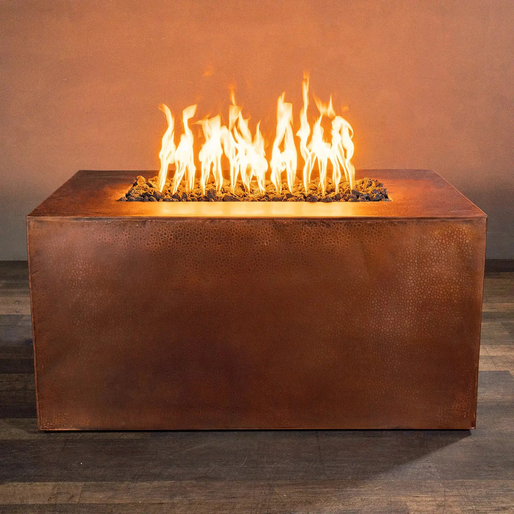 Front view of Gravity Moreno 48x32 rectangle copper fire pit with vibrant flames, highlighting the modern hammered copper finish, perfect for luxurious outdoor settings