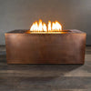 Front view of the Gravity Moreno 60x32 rectangular copper fire pit by Starfire Designs with vibrant flames, highlighting the rustic copper finish.