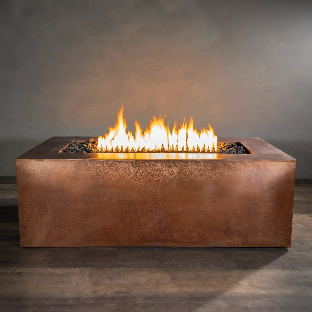 Front view of Gravity Moreno 72x38 copper fire pit by Starfire Designs, displaying a vibrant, full-length flame against a sleek copper finish