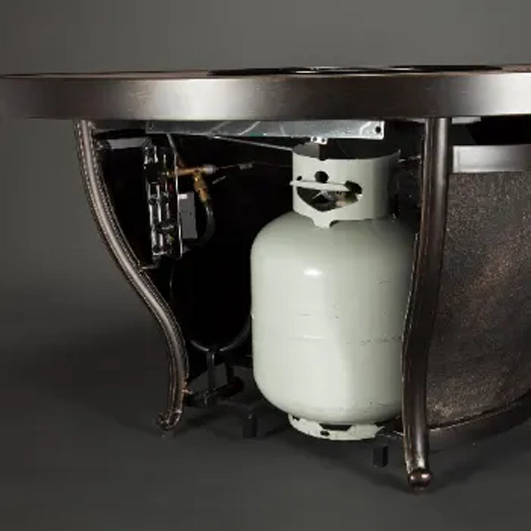 Underside view of a fire pit table showing the concealed storage compartment for a propane tank, with the tank securely in place and connected to the fire pit system.