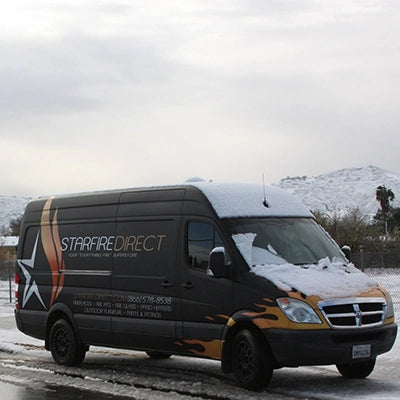 Starfire Direct van covered in snow, used for a cross-country delivery of a custom fire pit.