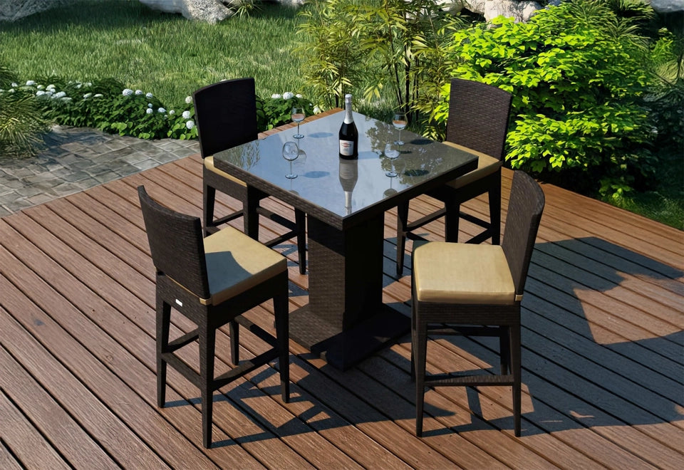 Contemporary outdoor bistro set featuring a sleek glass-top table with black wicker chairs and beige cushions, set on a natural wood deck with lush green surroundings.