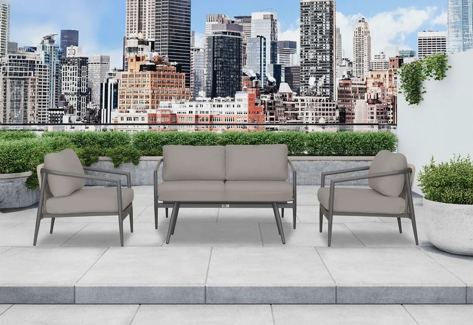 Contemporary gray patio sofa set with sleek metal frames, featuring a loveseat and two armchairs, arranged on an urban rooftop with stunning cityscape views.