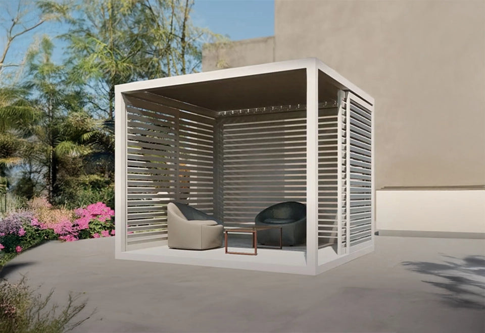 Modern white cabana with adjustable louvered sides, featuring cozy outdoor seating and a minimalist coffee table, set against a backdrop of vibrant garden blooms.