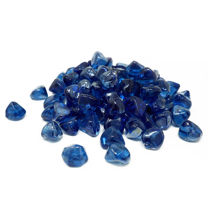 A small pile of Mr. Patio Fire Glass Fire-Diamonds in deep blue color displayed on a white background. The individually polished fire diamonds have a translucent finish, allowing them to reflect the flames beautifully. These glass stones are perfect for adding a striking visual element to fire pits, fireplaces, or gas fire tables. Made from high-quality tempered glass, these decorative fire diamonds are heat-resistant, ensuring long-lasting use in both indoor and outdoor settings