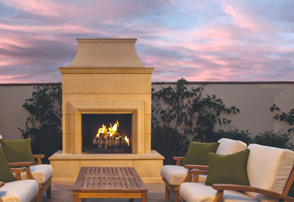 Elegant outdoor stone gas fireplace with a traditional direct vent design, featuring a warm and inviting flame display. Surrounded by cozy patio seating, this fireplace adds charm and functionality to luxurious outdoor living spaces, perfect for alfresco gatherings and enhancing backyard ambiance.