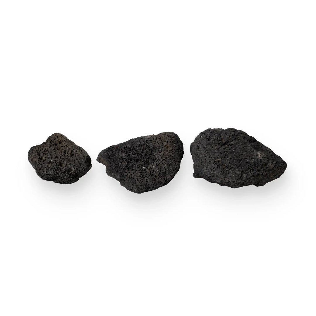 A group of three large volcanic lava rocks displayed in a studio setting. The dark-colored, porous stones highlight their rugged texture, making them an excellent choice for outdoor fire pits and fireplaces. These heat-resistant rocks are perfect for creating a natural, earthy fire feature that stands out. Each rock is unique, offering a bold, natural look for any outdoor fire setup