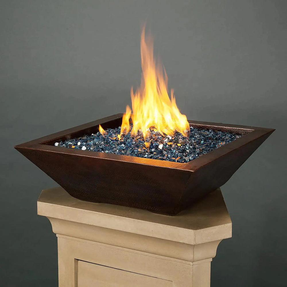 Plaza Moreno 29-inch square copper fire bowl with blue fire glass, showcasing a modern design and vibrant flames, perfect for outdoor patios or commercial settings
